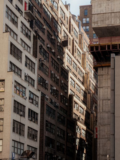 Free A narrow city alley lined with tall residential buildings, showcasing urban architecture and vibrant windows. Stock Photo