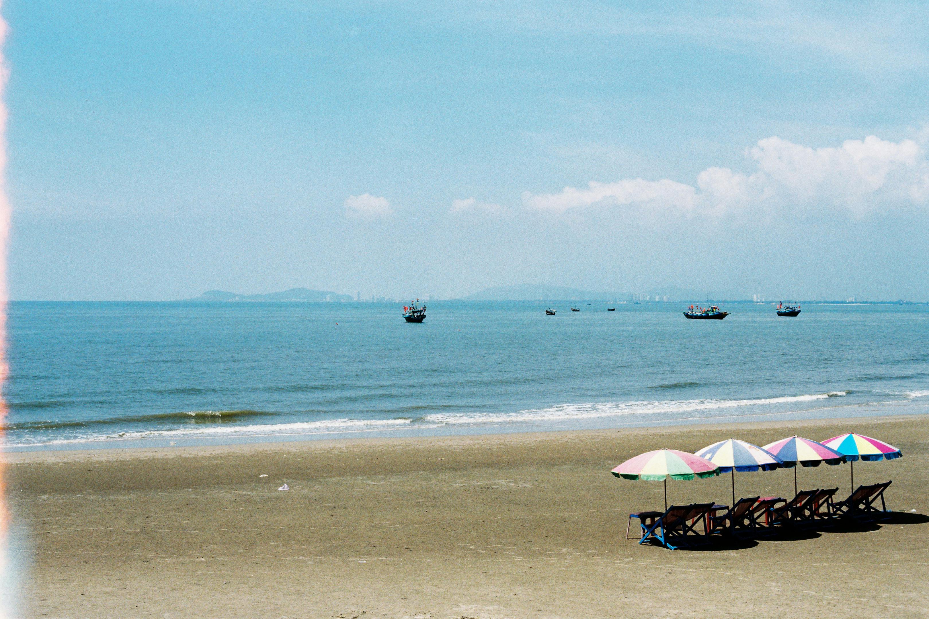 Relaxing beachfront view with umbrellas and chairs on a sunny day in Ba Ria - Vung Tau, Vietnam.