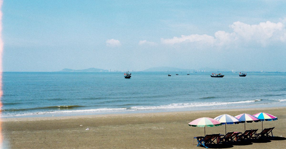 Relaxing beachfront view with umbrellas and chairs on a sunny day in Ba Ria - Vung Tau, Vietnam.