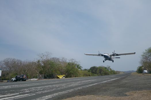 A small aircraft takes off from a rural airstrip, showcasing adventure travel.