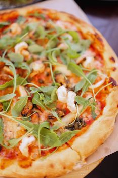 Delicious seafood pizza topped with fresh arugula and cheese, perfect for a gourmet meal.