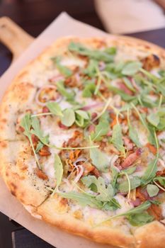 Delicious freshly baked pizza topped with arugula, cheese, and veggies, perfect for a gourmet meal.