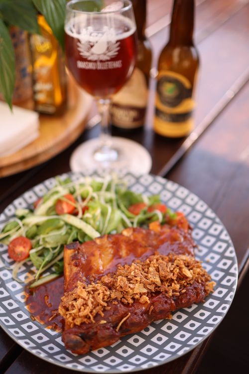 Free Savory barbecue ribs with fresh salad, paired with craft beer, served on a rustic table. Stock Photo
