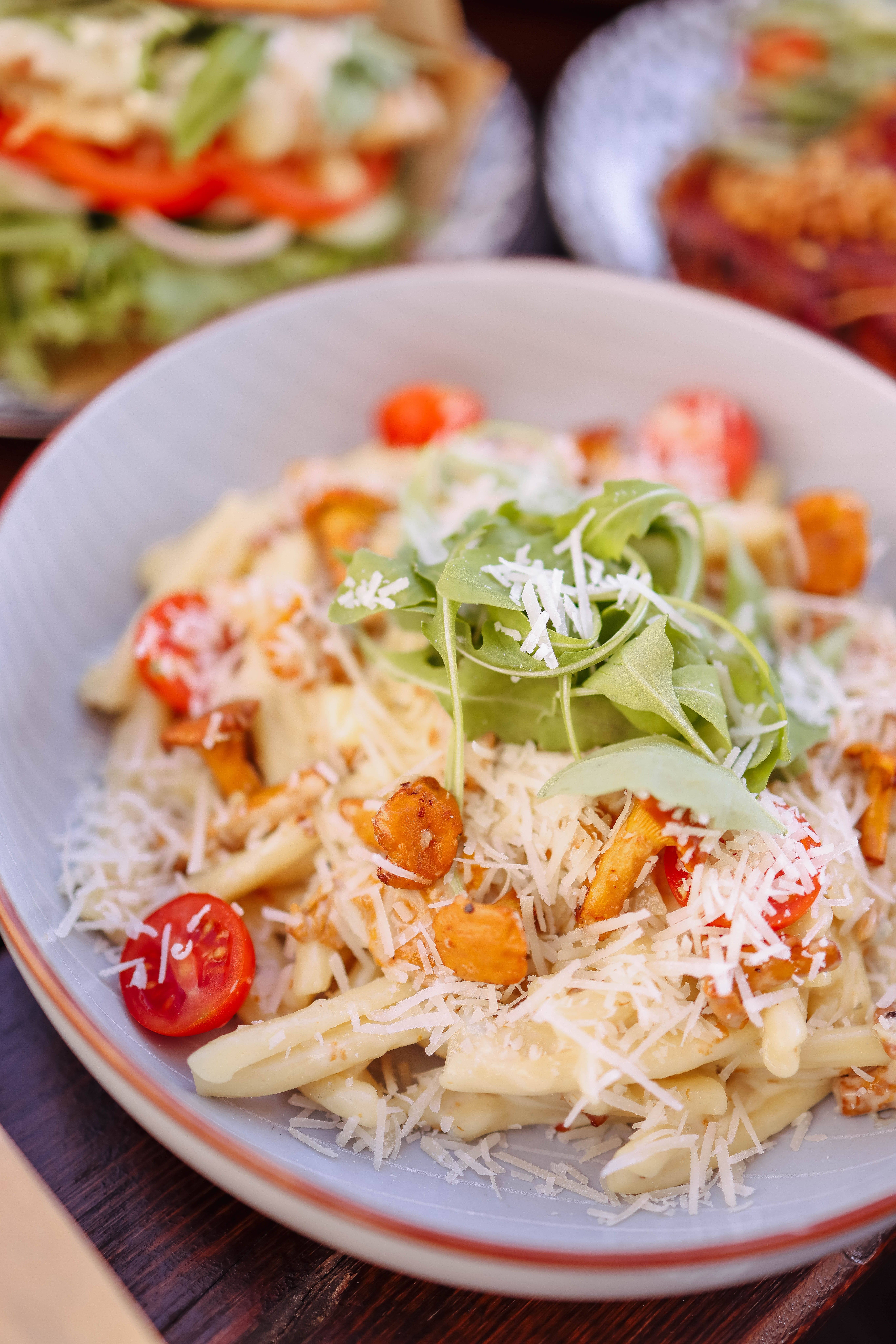 Delicious pasta with cherry tomatoes, arugula, and Parmesan cheese.