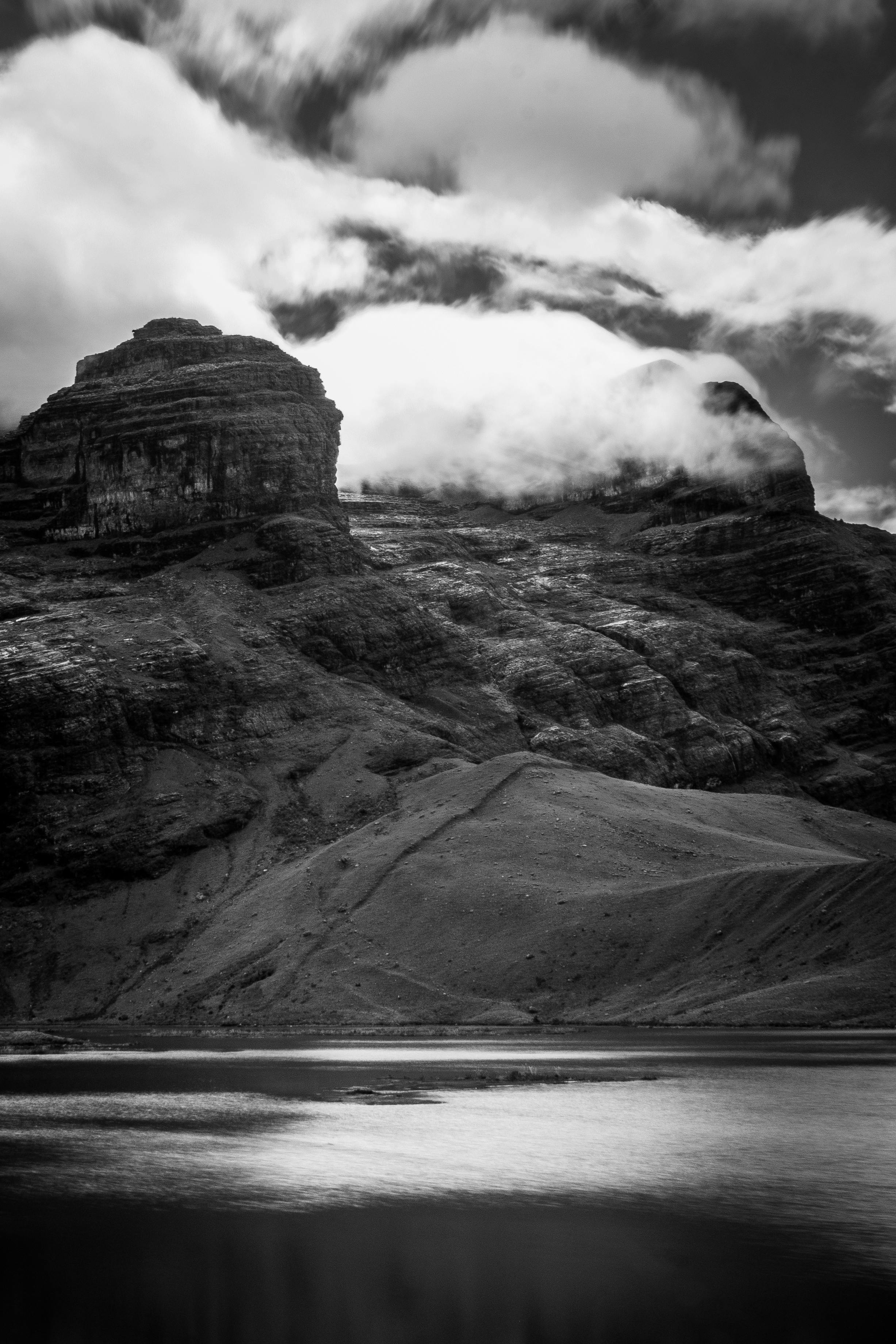 Stunning black and white photo of a mountain reflected in a tranquil lake.