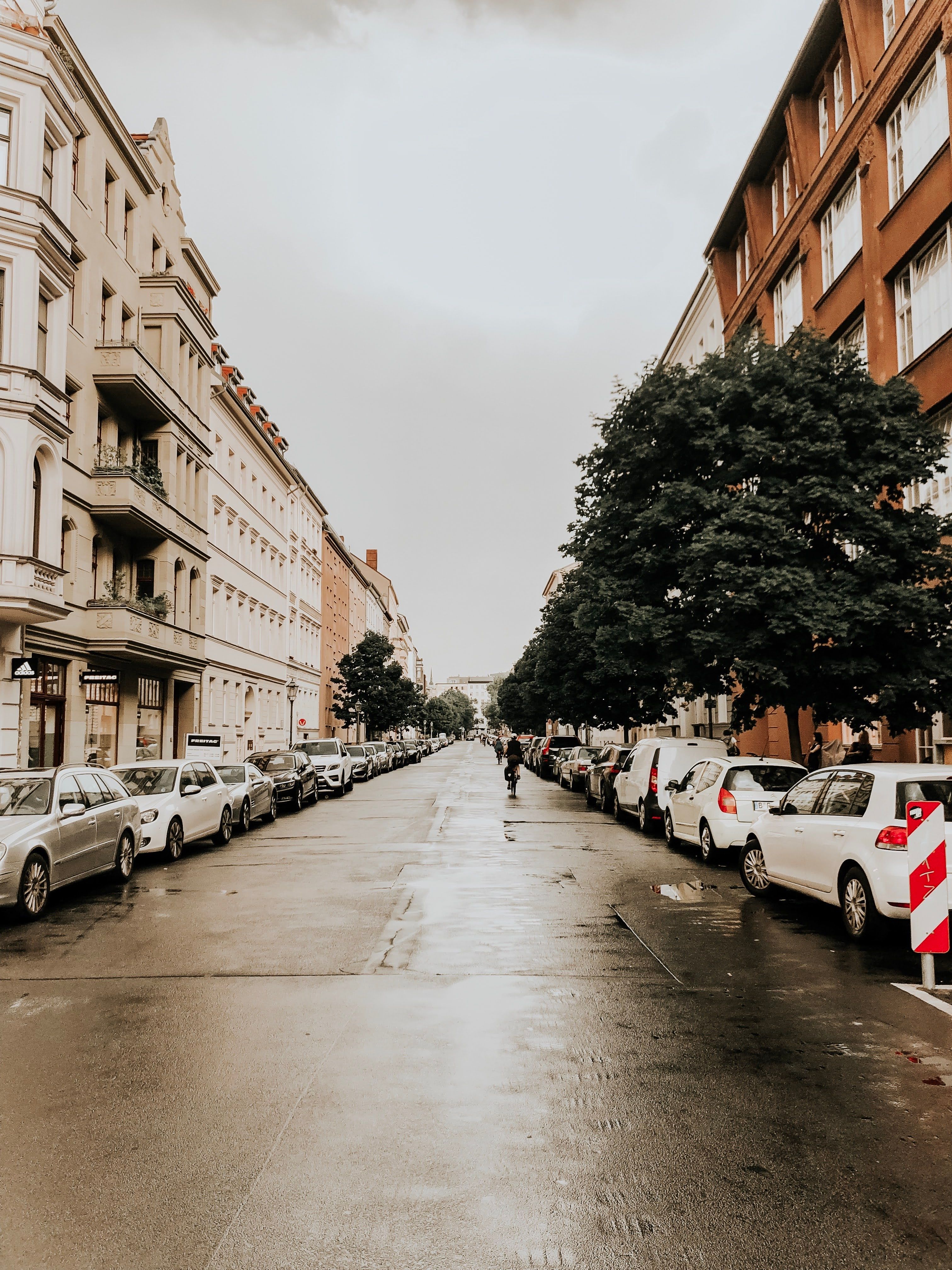 A rainy street with cars parked on it · Free Stock Photo