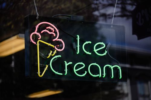 Free Colorful neon ice cream sign glowing in the dark, creating a vibrant urban atmosphere. Stock Photo