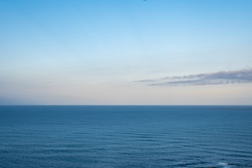 Free Peaceful ocean view at sunset with clear blue skies in Brittany, France. Stock Photo