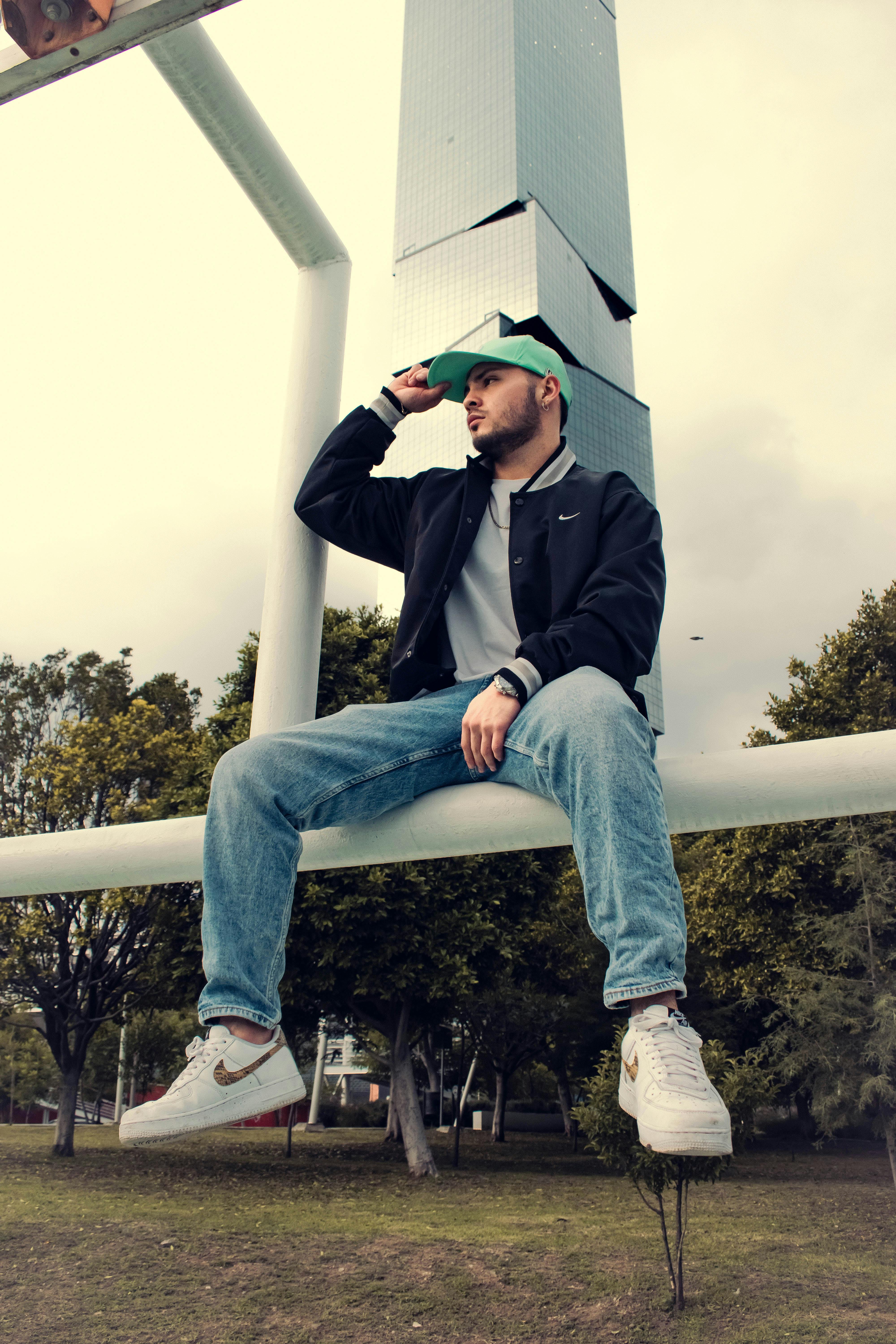 a man sitting on top of a pole with his feet up