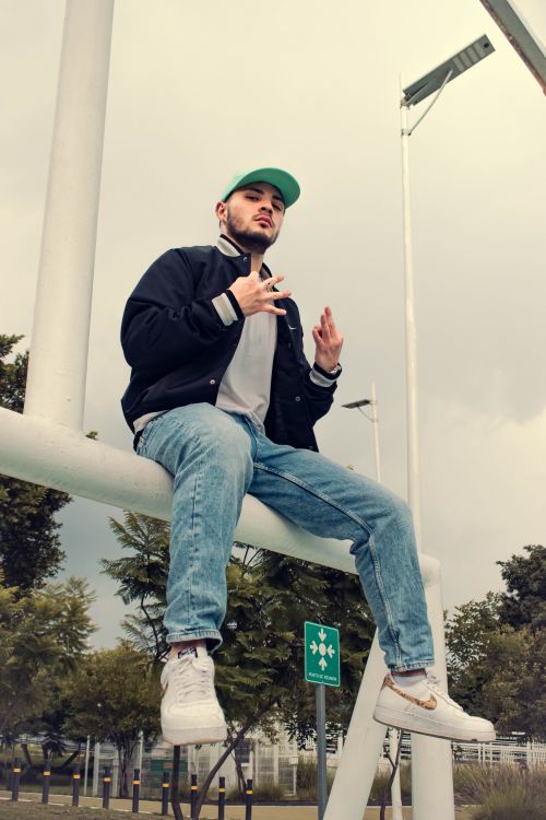 Free A trendy young man poses confidently on a structure outdoors in Puebla, Mexico. Stock Photo