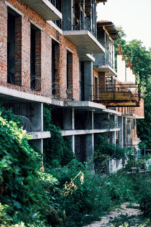 Free A partially constructed building overtaken by lush greenery, showcasing urban decay. Stock Photo