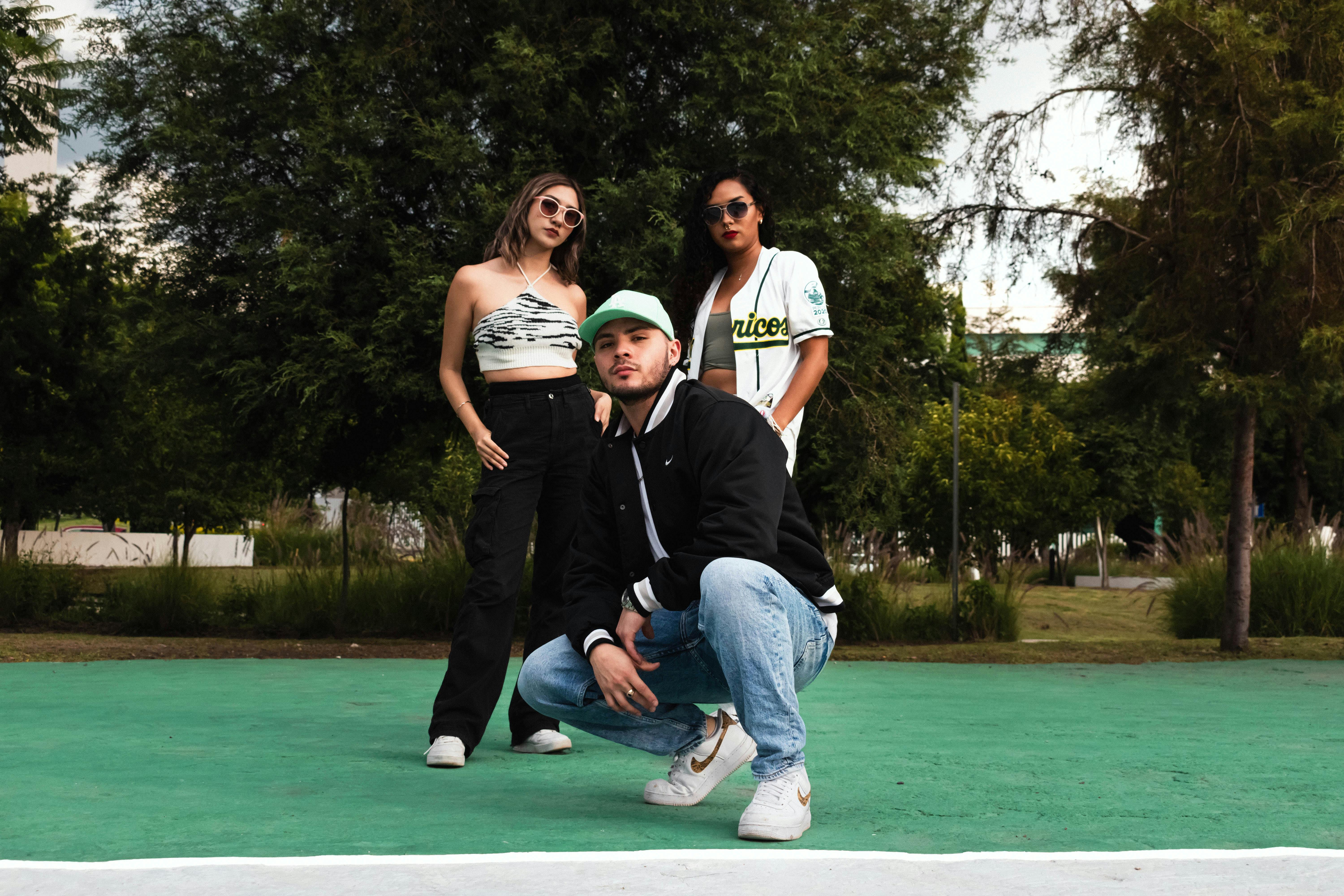 three people posing for a photo on a tennis court