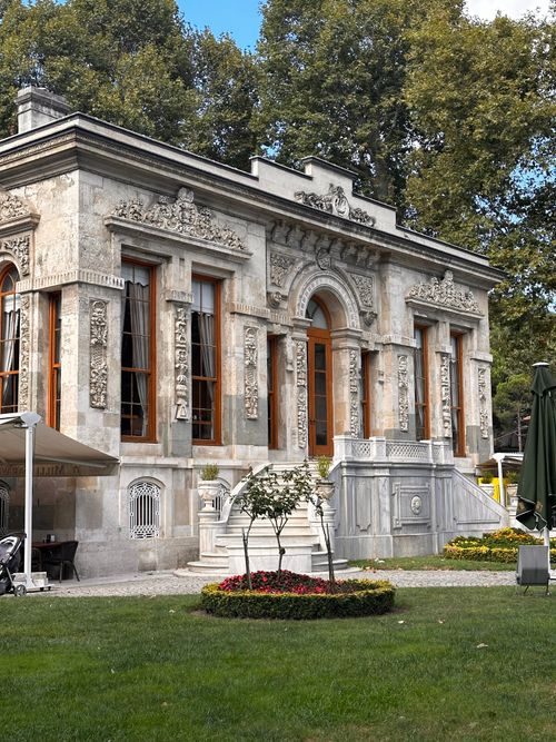 Free A stunning historic mansion with decorative architecture, set in a lush garden. Stock Photo