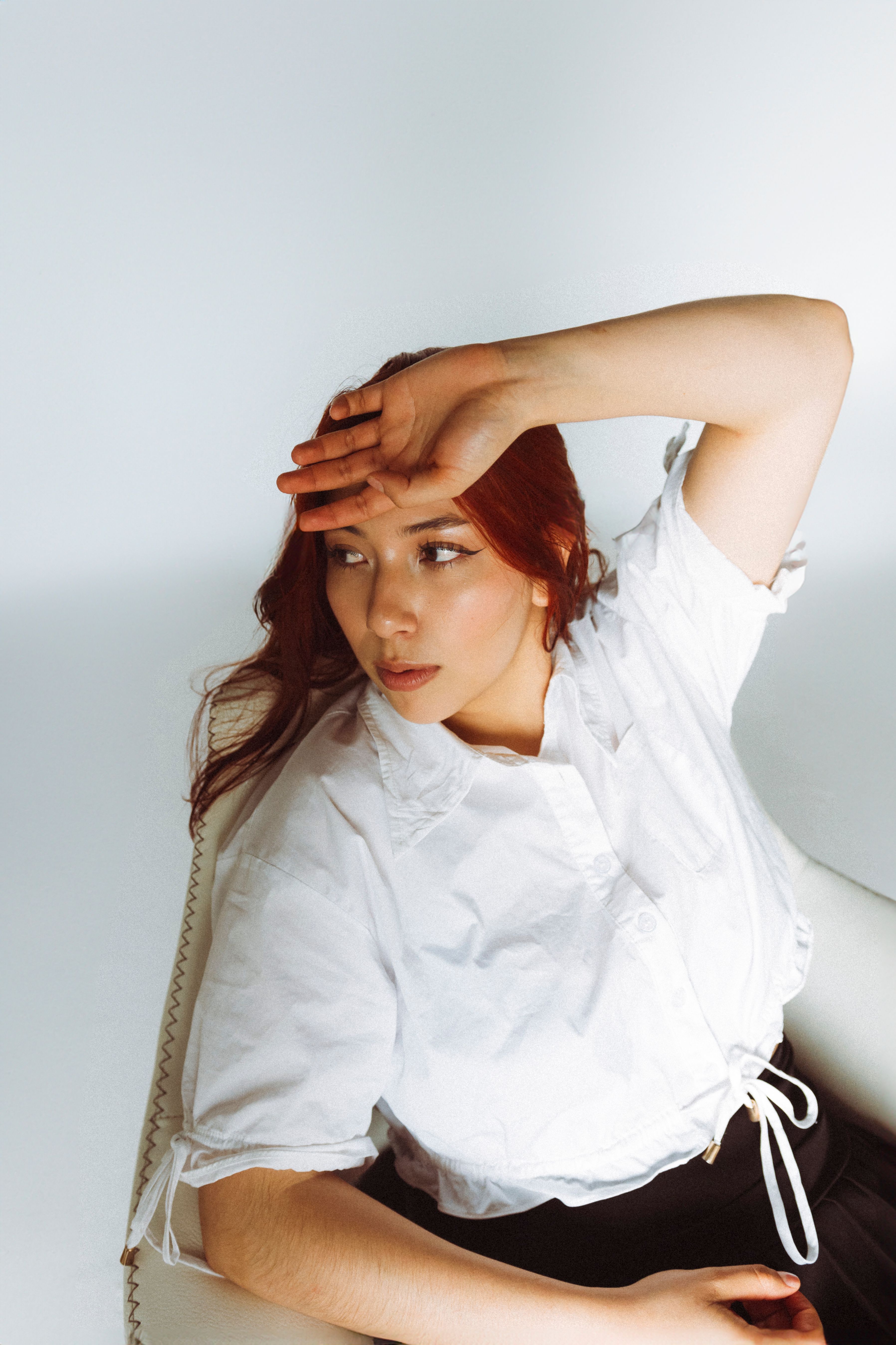 A woman with red hair sitting in a chair · Free Stock Photo