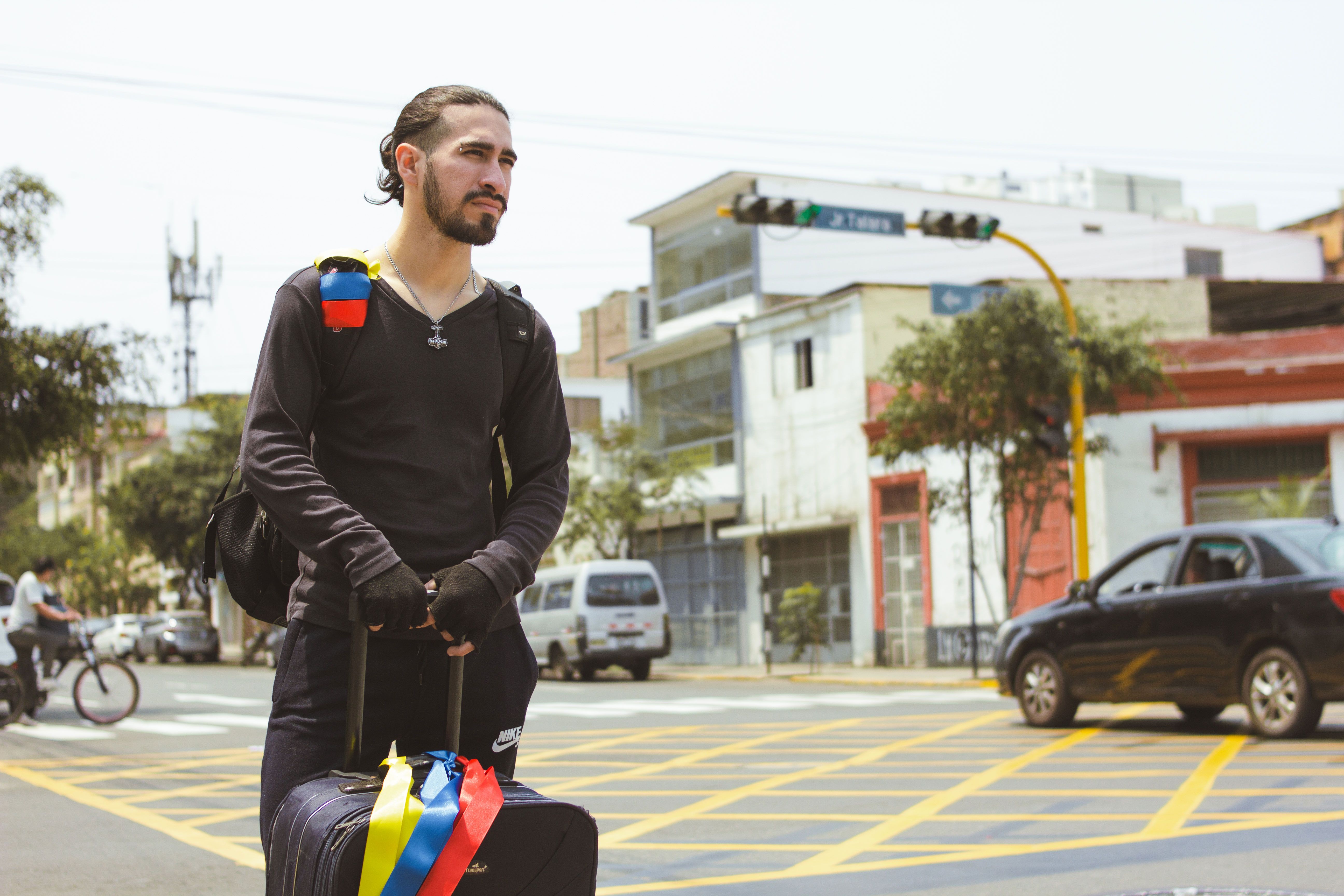 Man with suitcase on a street in Lima, Peru, depicting urban travel scene.