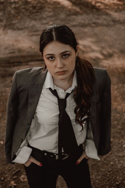 Free Young woman in formal attire standing outdoors with a confident gaze. Autumn feel. Stock Photo