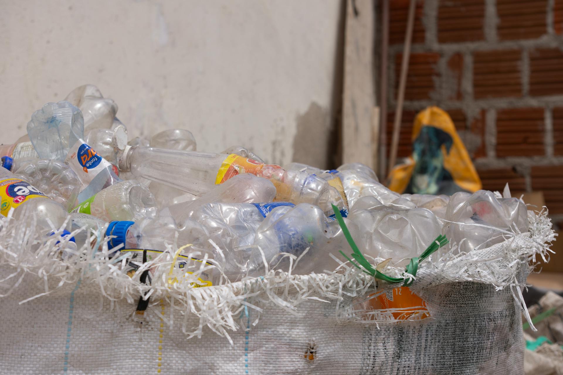 A collection of plastic bottles in a bin, ready for recycling, outdoors.