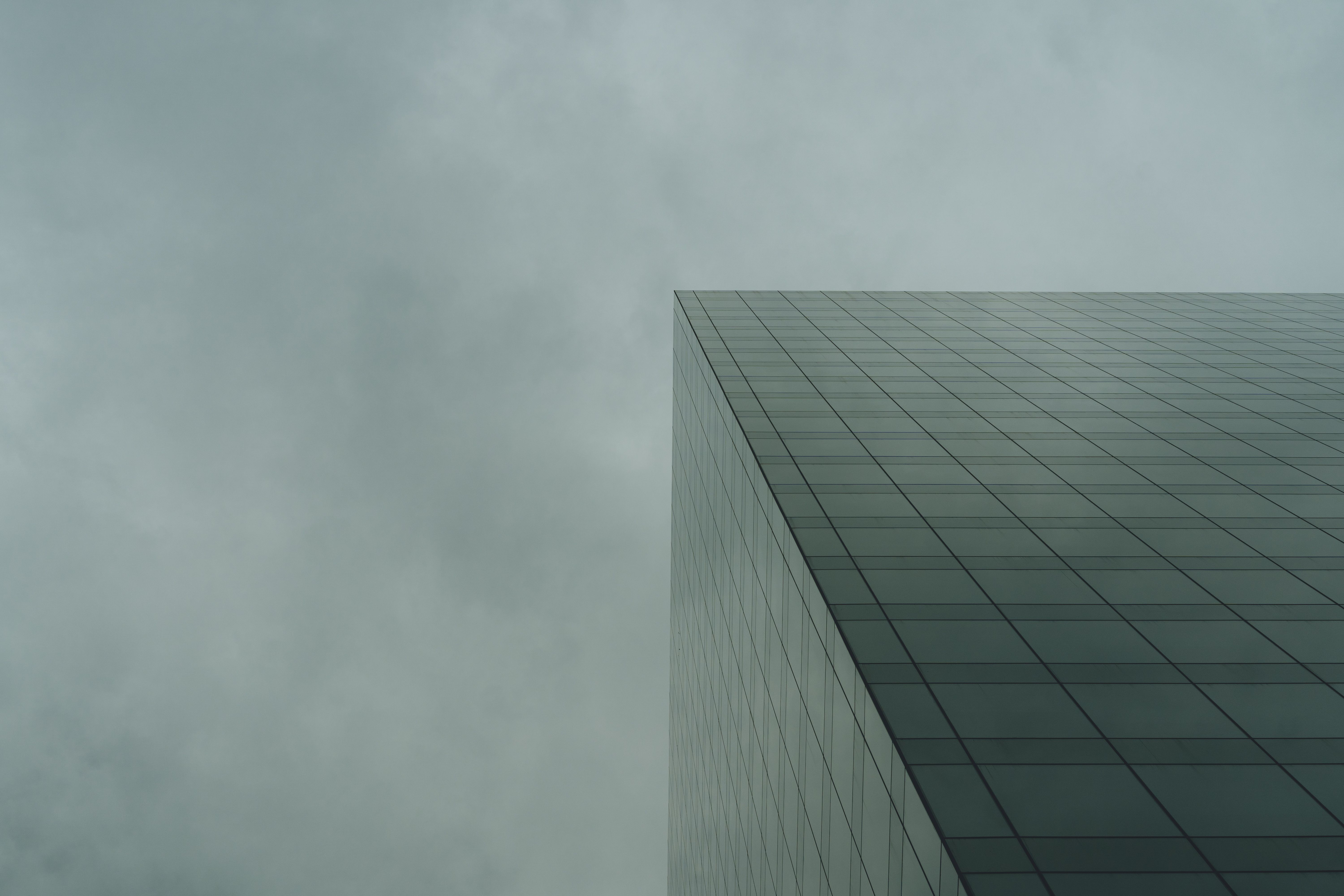 A tall building with clouds in the sky · Free Stock Photo