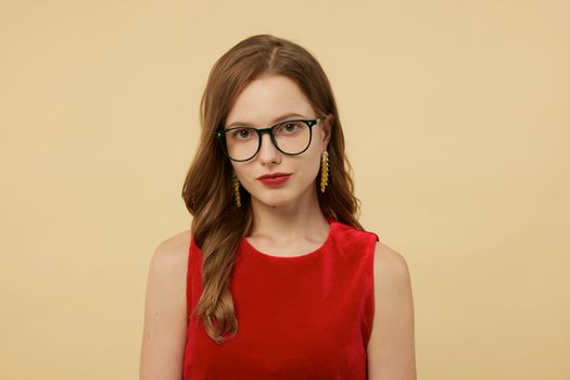 Sophisticated portrait of a young woman in red velvet, wearing chic eyeglasses and earrings.