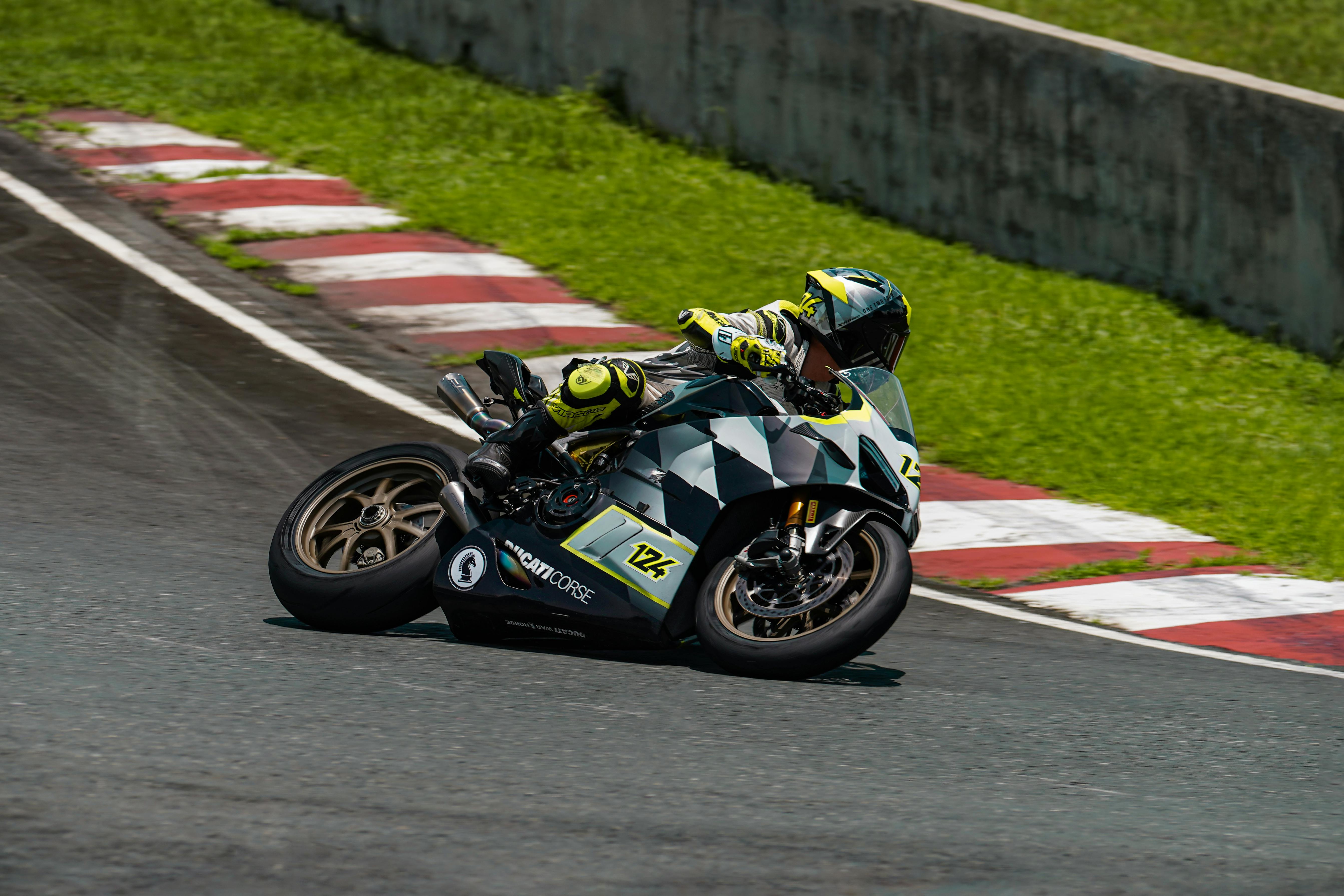 Motorcycle racer leans into a curve at Batangas race track, showcasing speed and agility.