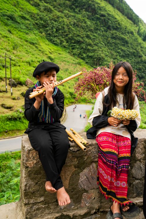 Free Two children in traditional dress enjoying a scenic mountain landscape. Stock Photo