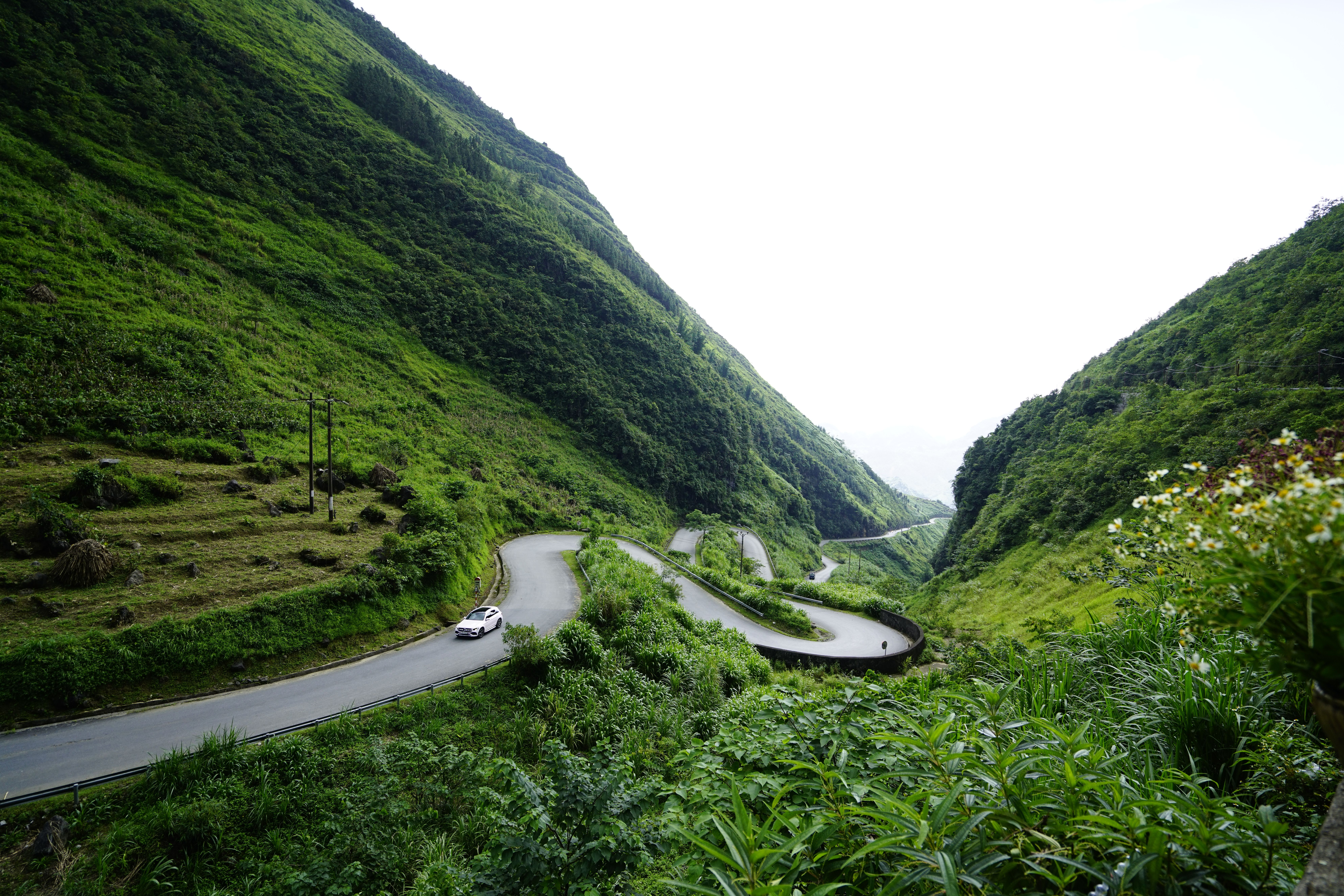 A winding road in the mountains with a car driving down it · Free Stock ...