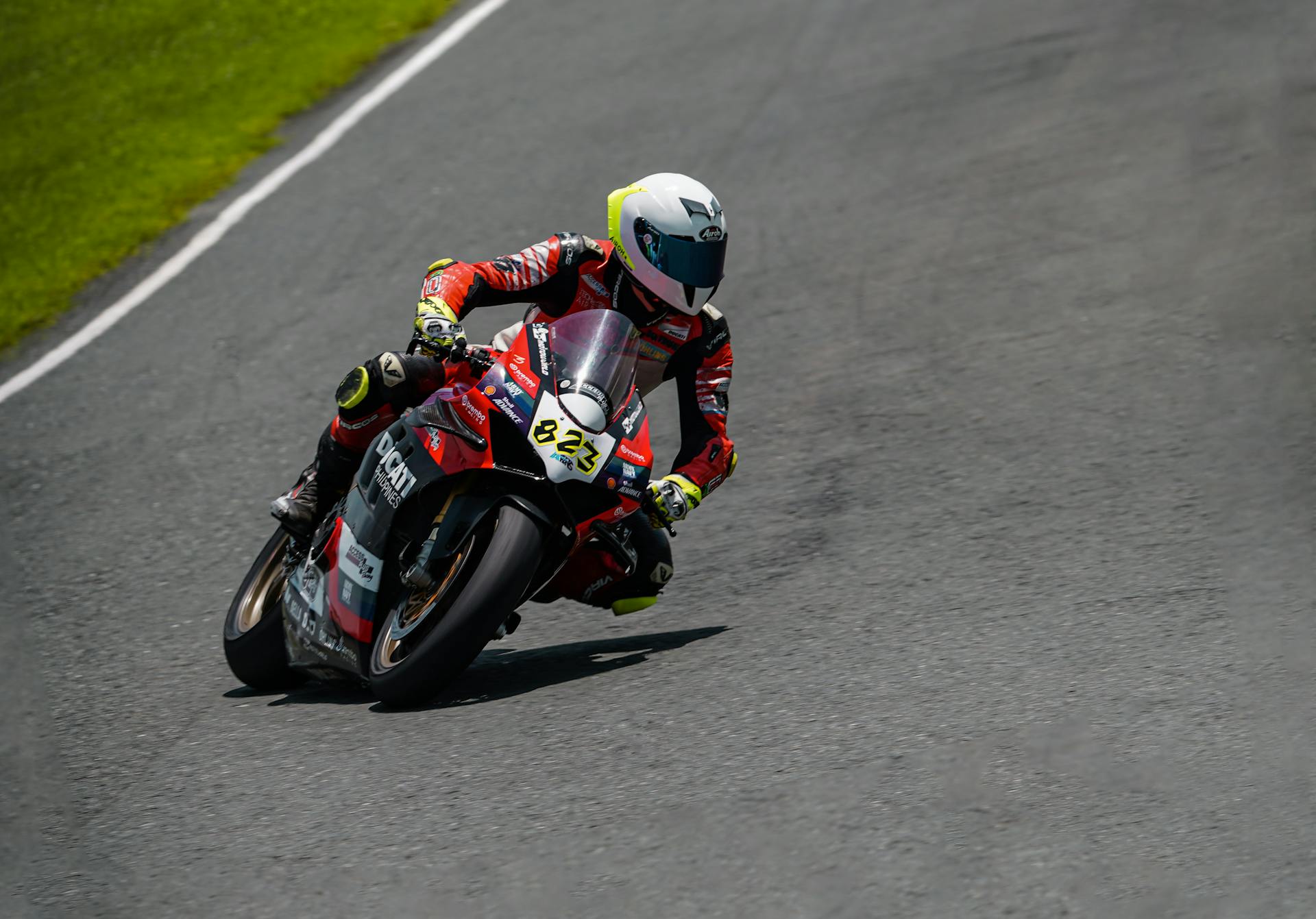 Motorcycle racer leaning into a curve on Batangas racetrack during an intense competition.