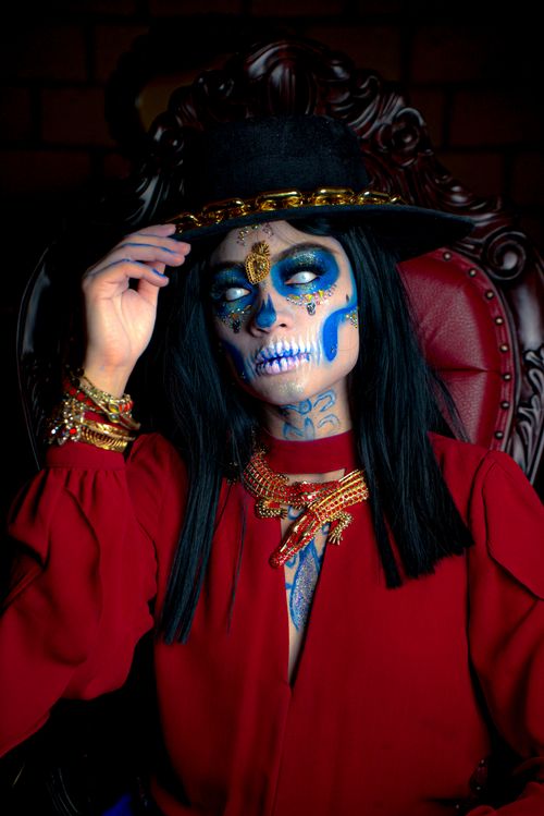Free Vibrant Catrina portrait with colorful face paint and ornate attire. Stock Photo