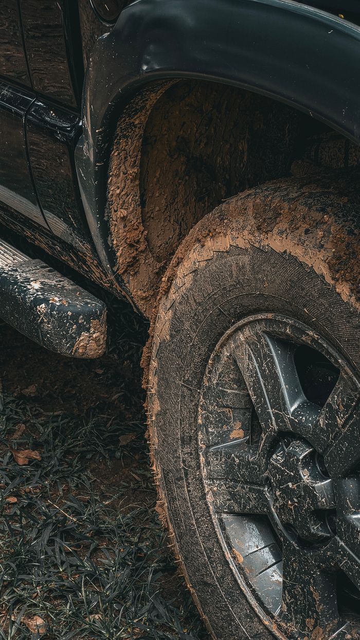 Mud-caked off-road tire and wheel on a truck