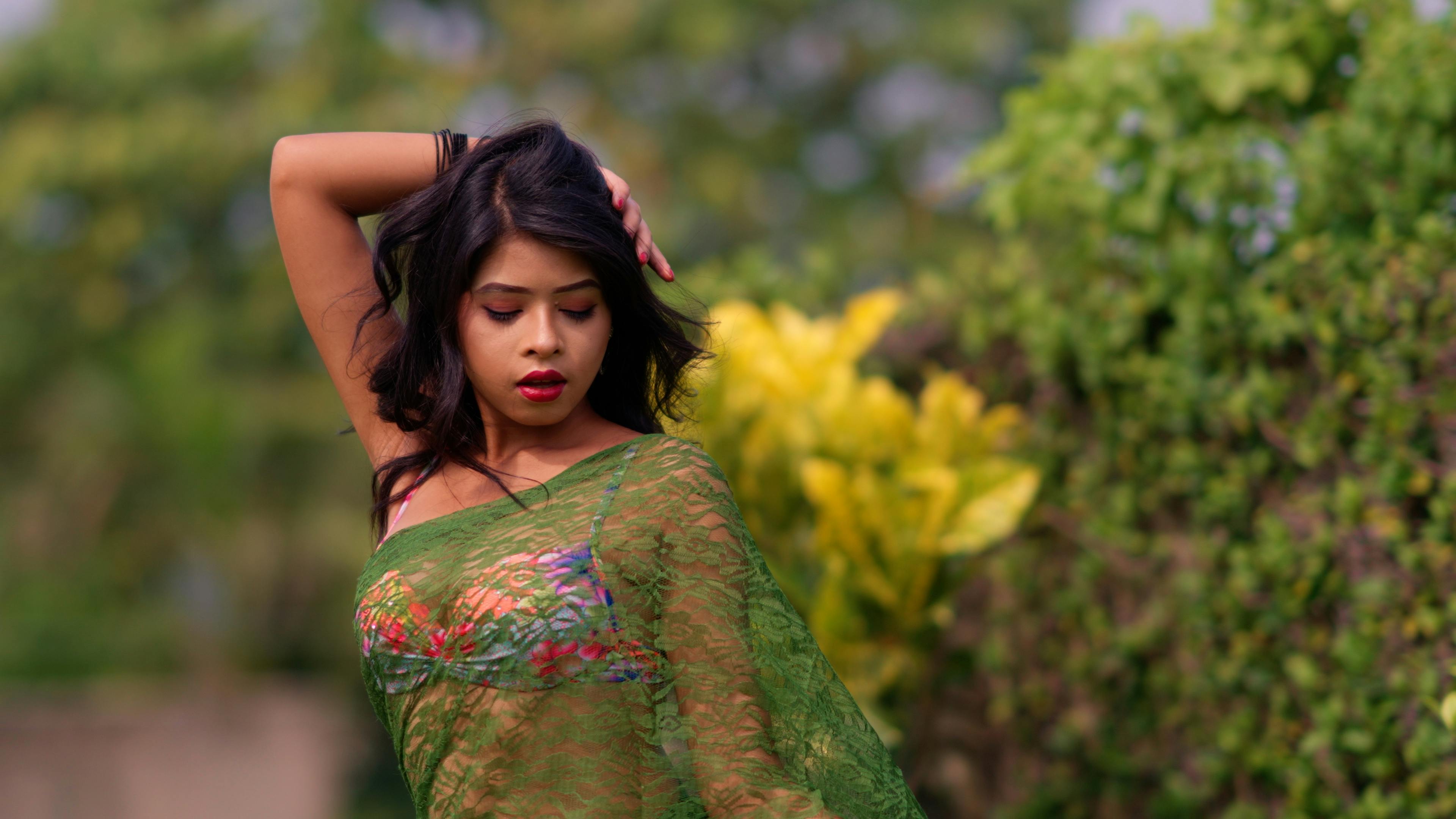 a woman in a green sari posing for the camera