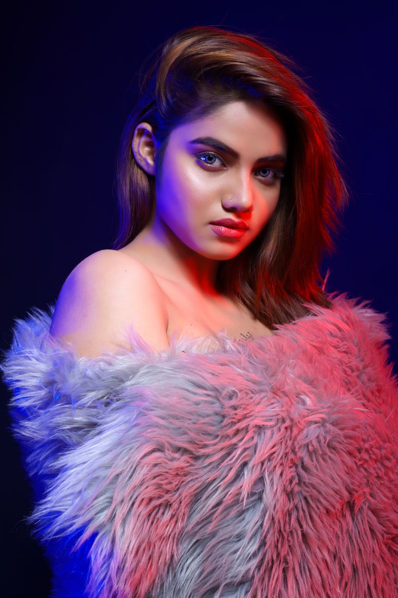 Elegant portrait of a woman in a fur wrap with colorful lighting.