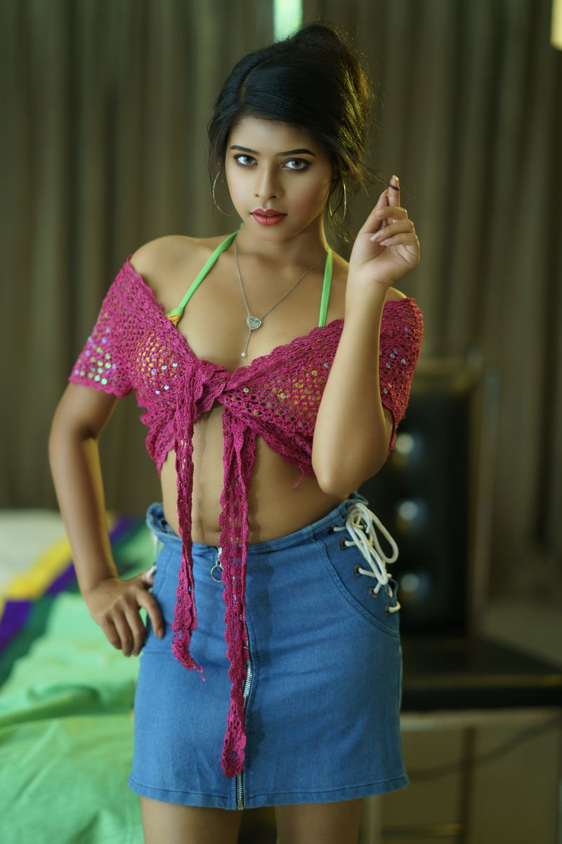 Young woman in a vibrant summer outfit posing confidently indoors.