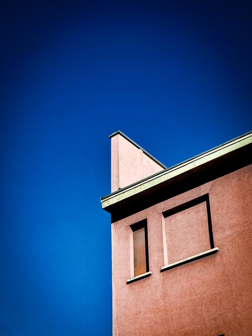 Free A minimalist building facade under a clear, vibrant blue sky, showcasing modern architecture. Stock Photo