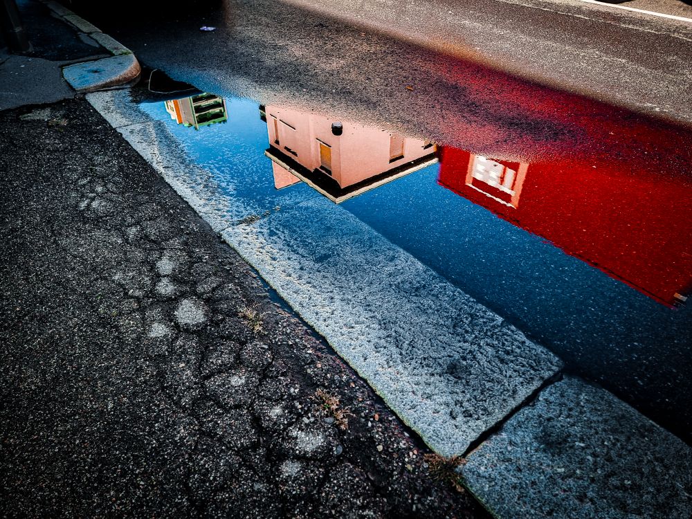 A reflection of a building in a puddle · Free Stock Photo