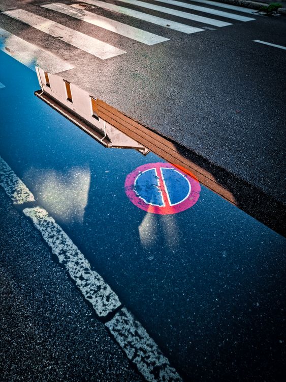 A reflection of a street sign in a puddle · Free Stock Photo