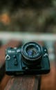 Selective Focus Close-up Photo of Black Camera on Wooden Surface