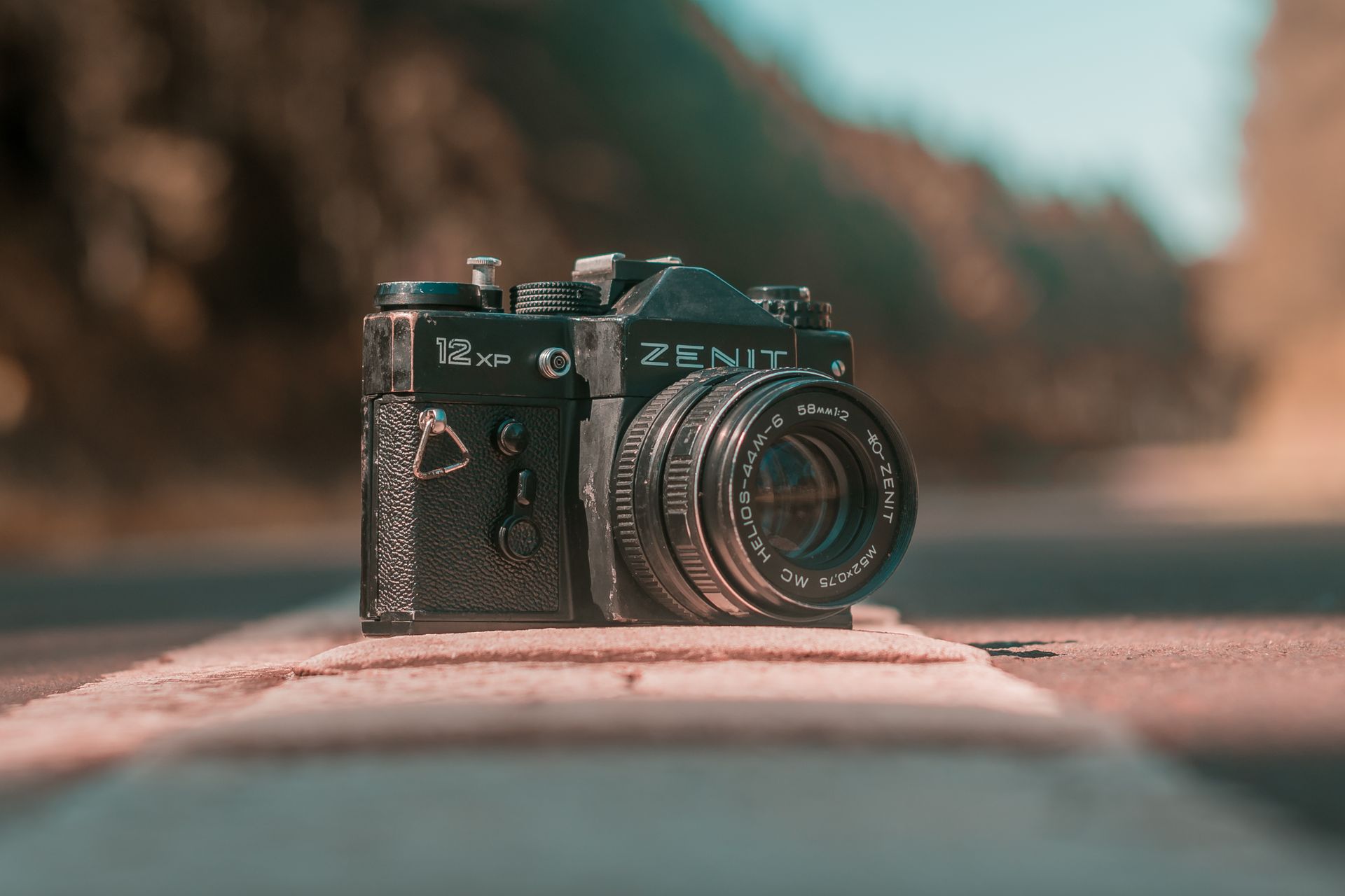 Close-up of a classic Zenit camera with Helios lens on an outdoor road.