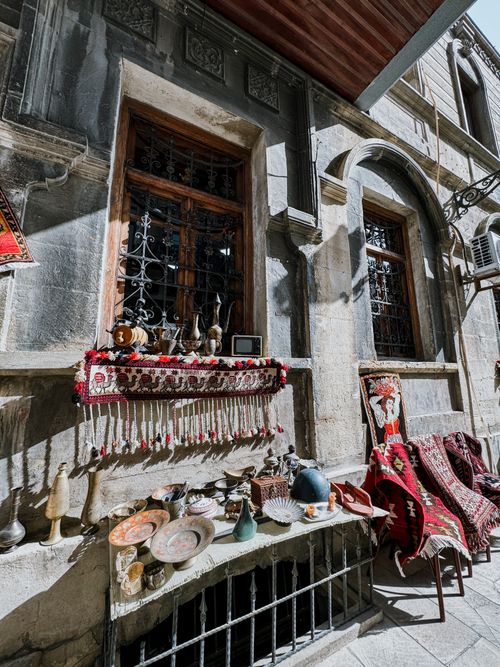 Free Street view of a traditional market displaying antique decor and cultural textiles in an urban setting. Stock Photo