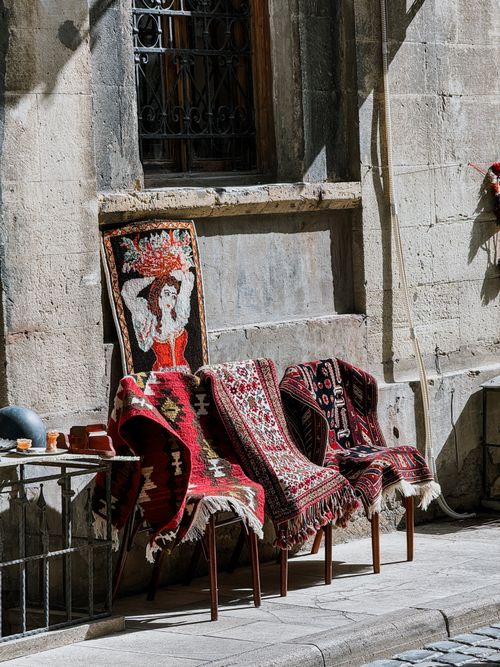 Free Colorful antique rugs displayed in an old town, showcasing traditional patterns and craftsmanship. Stock Photo