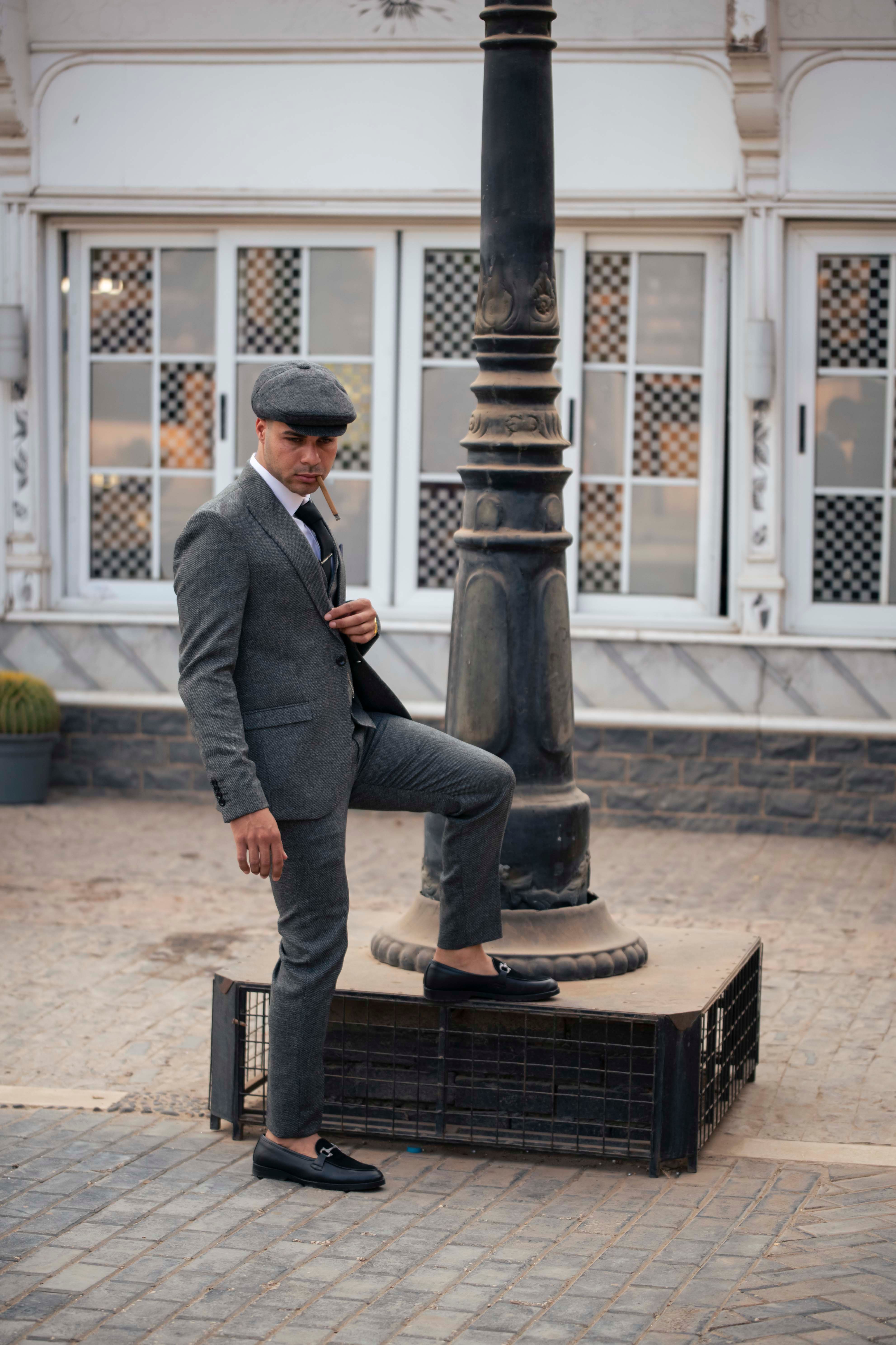 A man in a suit and hat is leaning on a lamp post · Free Stock Photo