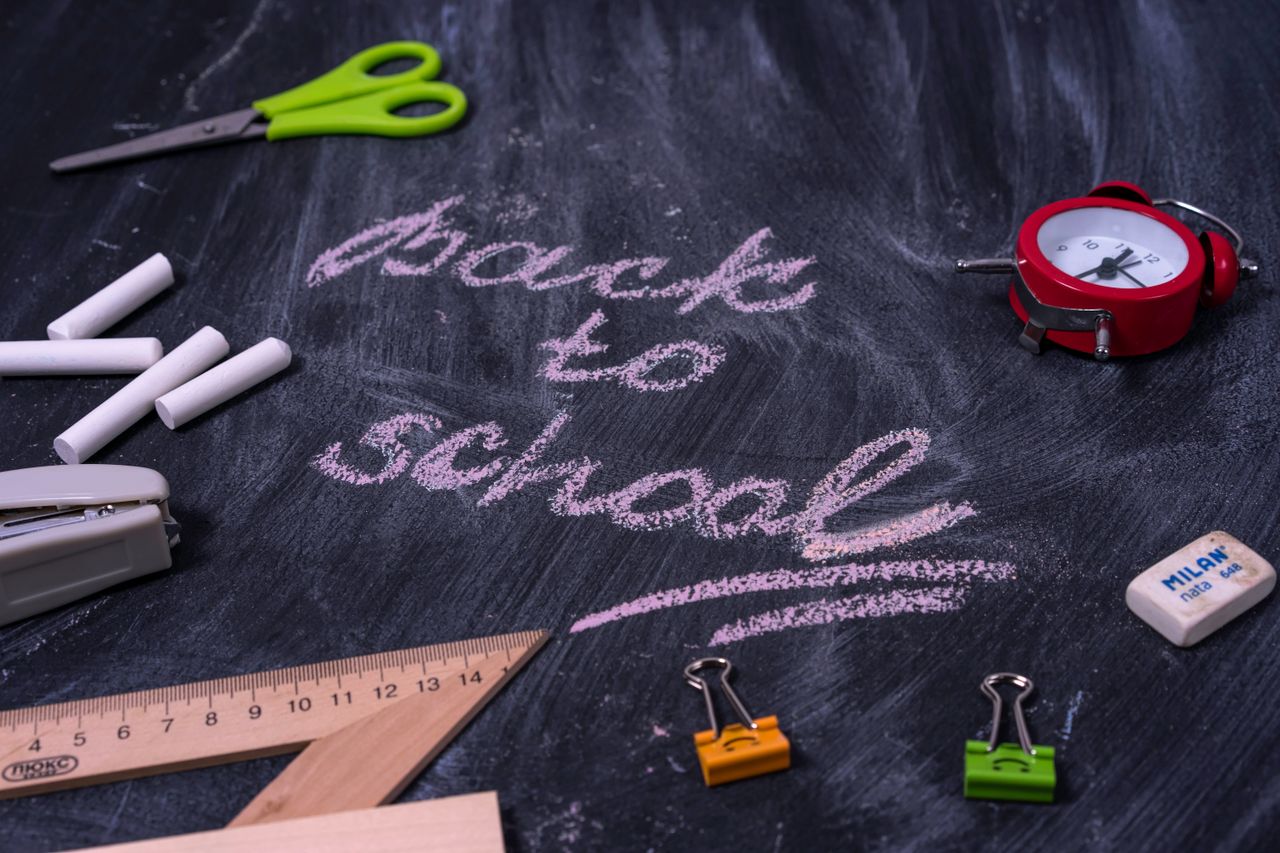 an arrangement of school supplies with back to school written on a cha