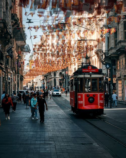 Free Vibrant Istanbul street scene featuring a classic red tram surrounded by busy urban life. Stock Photo