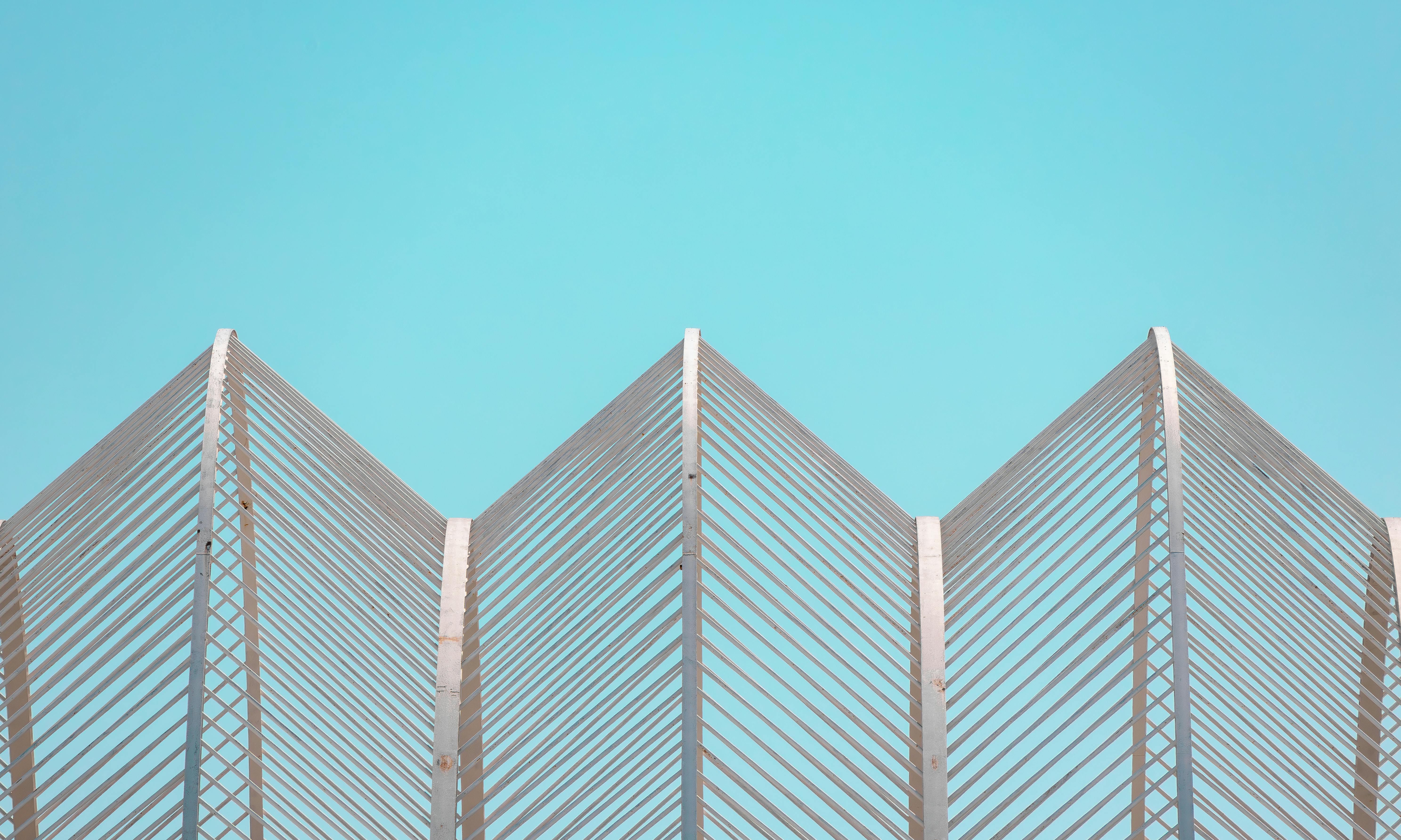 a metal fence with a blue sky in the background