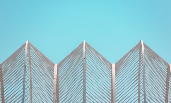 Contemporary geometric architectural structure set against a clear blue sky in Valencia.