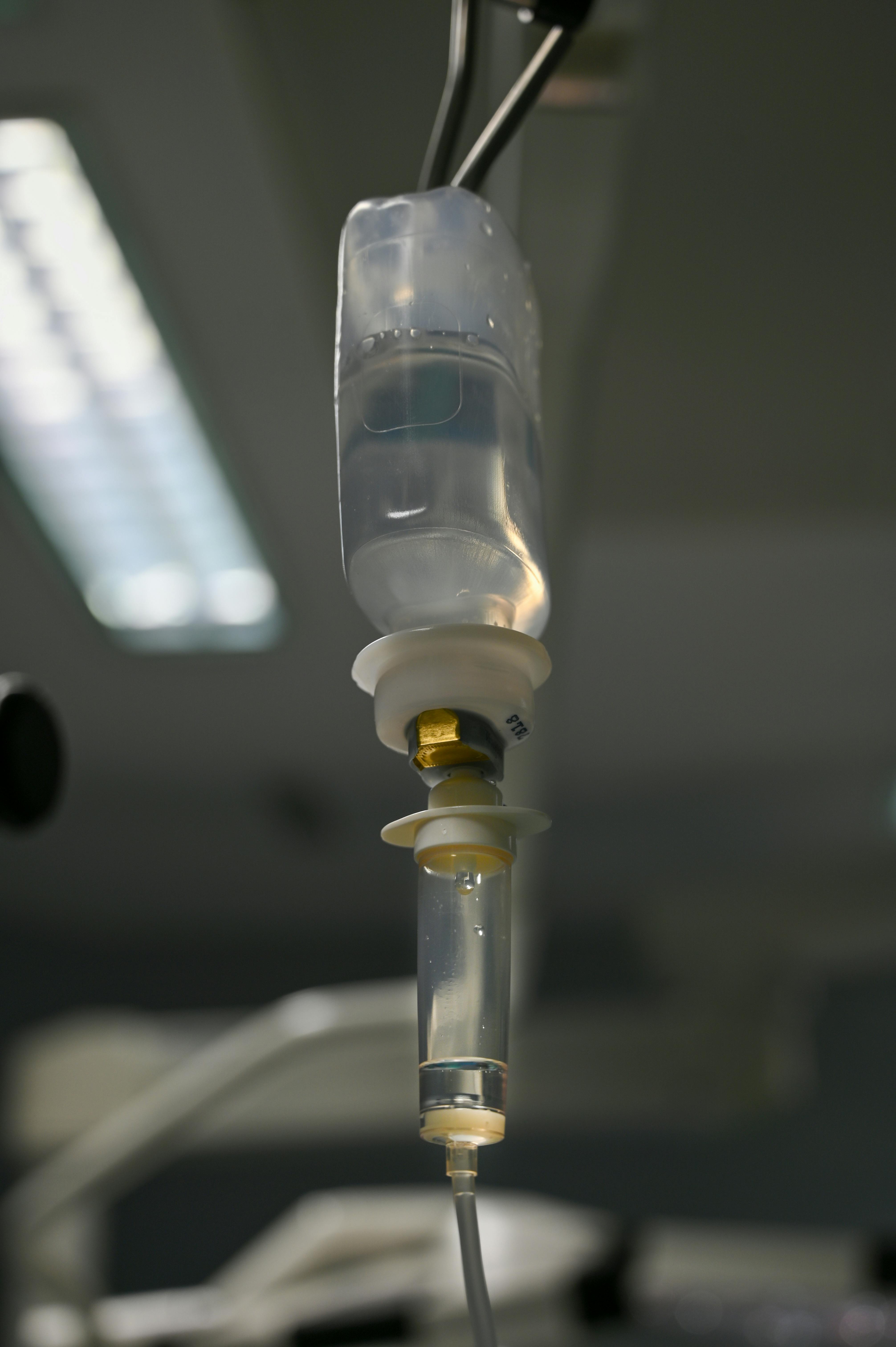 Closeup view of an IV drip system in a sterile hospital setting, illustrating medical equipment and healthcare.