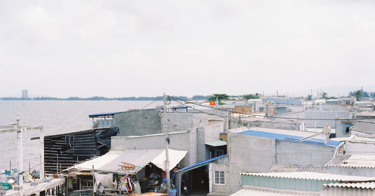 Rustic coastal village scene in Ba Ria, showcasing seaside buildings and calm waters.