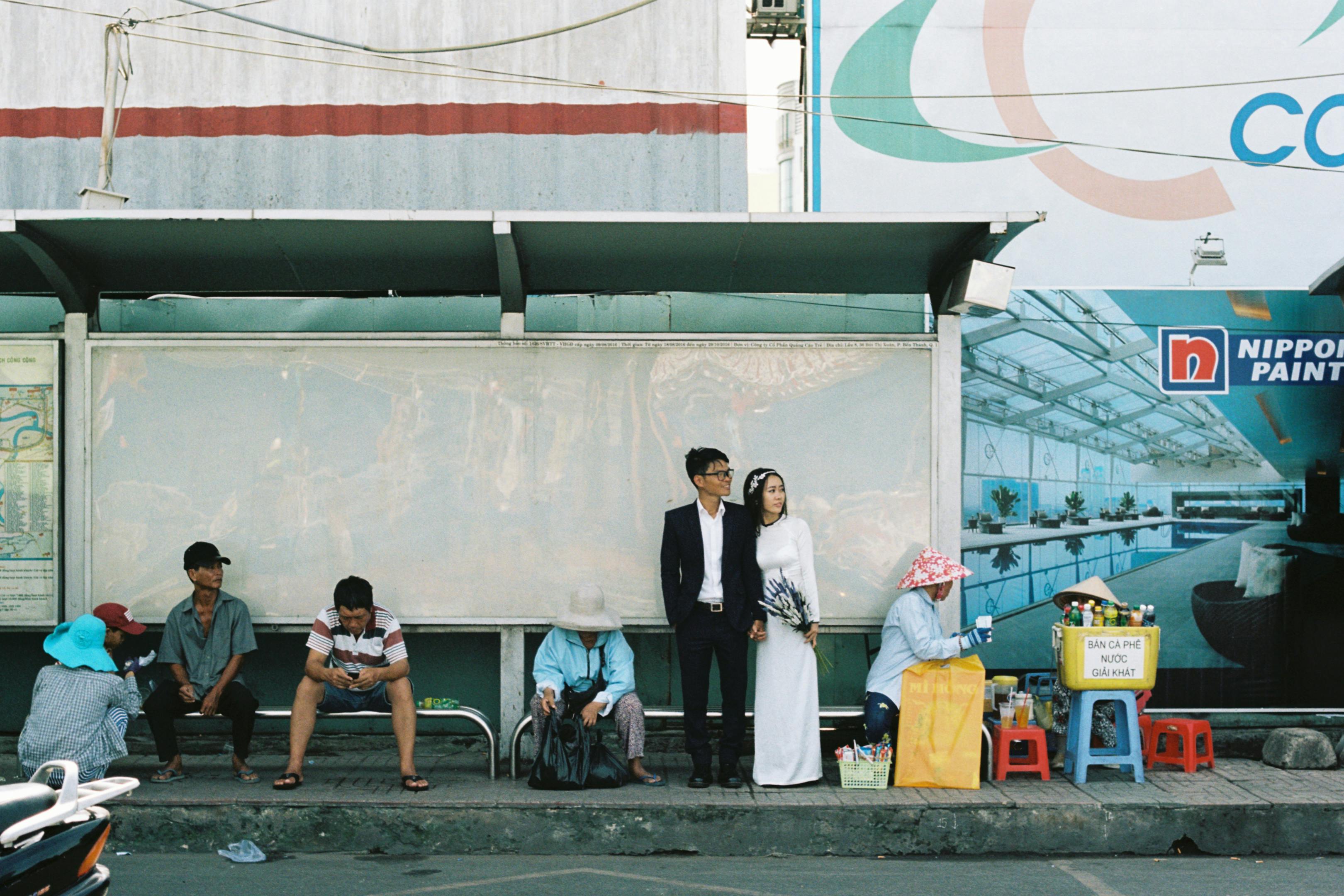 a couple is standing on the side of a bus