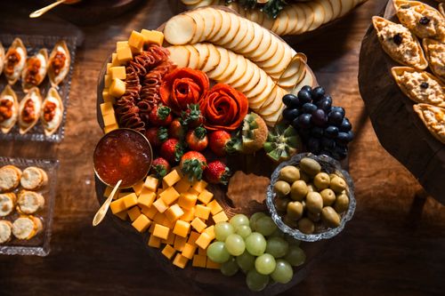 Free Elegant cheese and fruit platter with diverse appetizers on a wooden table. Stock Photo