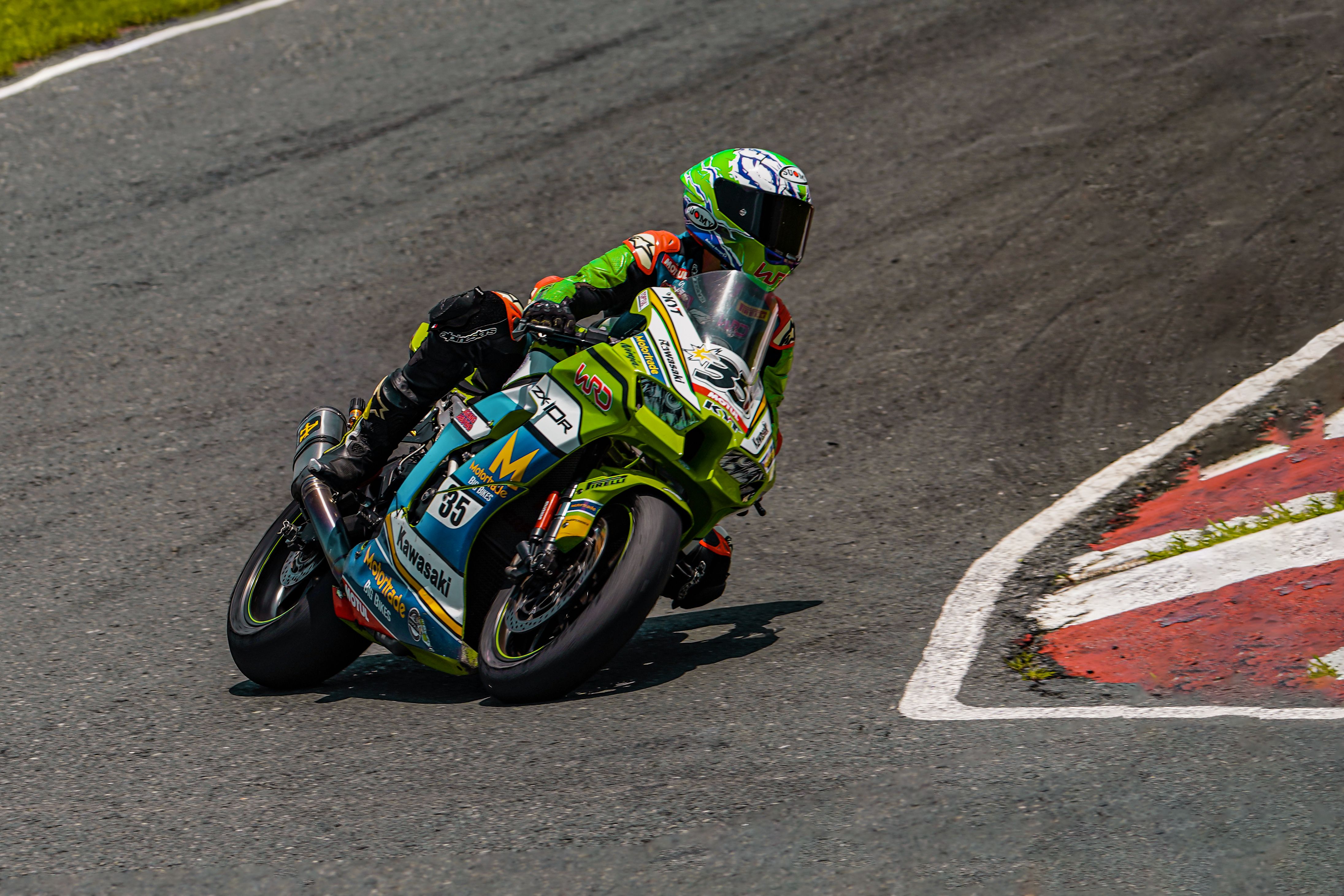 Dynamic shot of a motorcyclist racing during a turn on a professional track. Action-packed and thrilling scene.