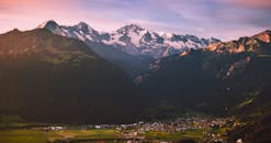 日落时分，俯瞰一座安静的山谷小镇，壮丽的白雪皑皑的山脉